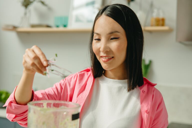 nutritionist adding herbs to sauce